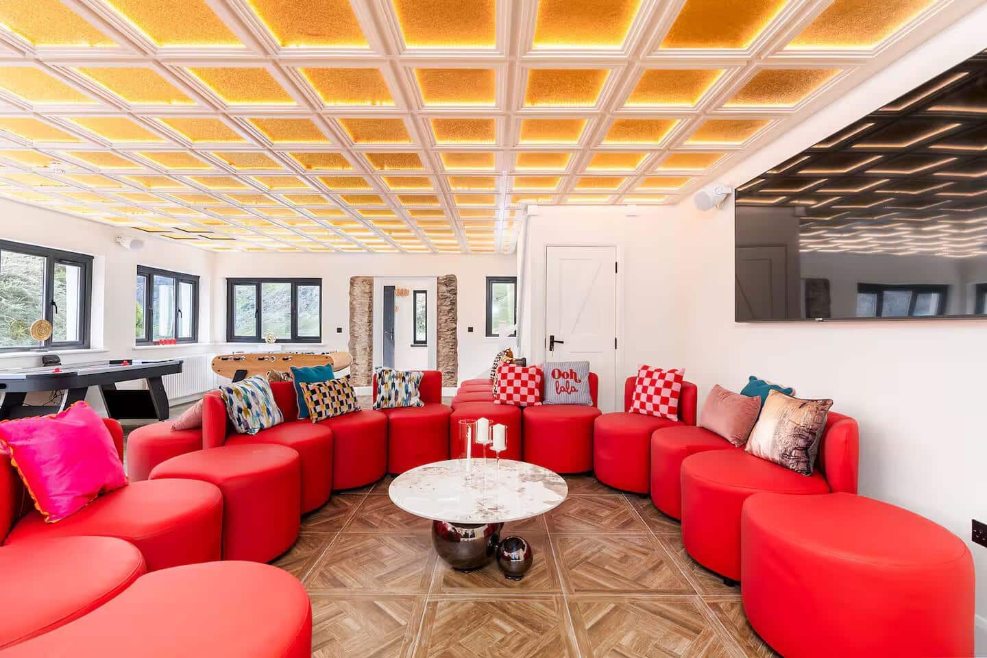Large group accommodation for 13 guests with a designer red sofa and golden ceilings